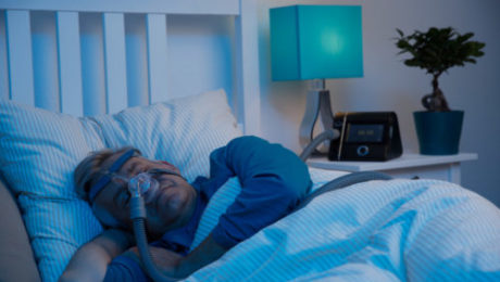 Śpiący mężczyzna w masce CPAP do terapii bezdechu sennego