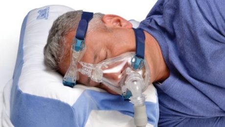 Dobór aparatu CPAP to również dobór akcesoriów. Mężczyzna śpi na poduszce do CPAP