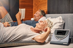 Kobieta i mężczyzna w łóżku stosują terapię BEMER na zdrowy sen